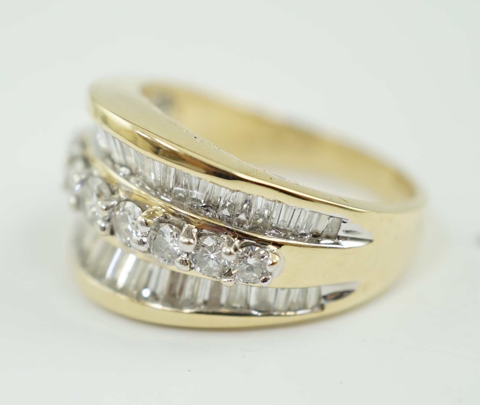 A modern 14k gold and three row baguette and round brilliant cut diamond set dress ring, based on the design of the Crown on the Statue of Liberty